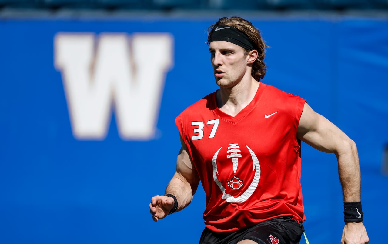 A flag football player in a red and white singlet runs