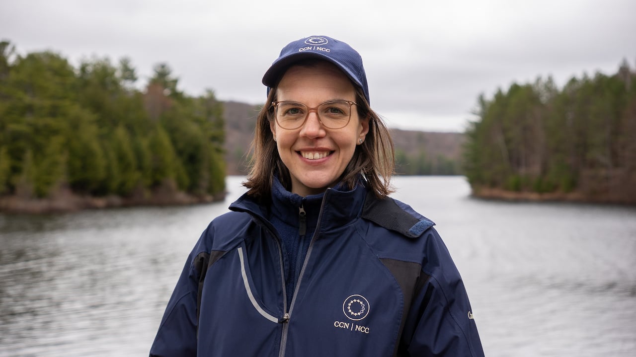 A person stands by a lake.