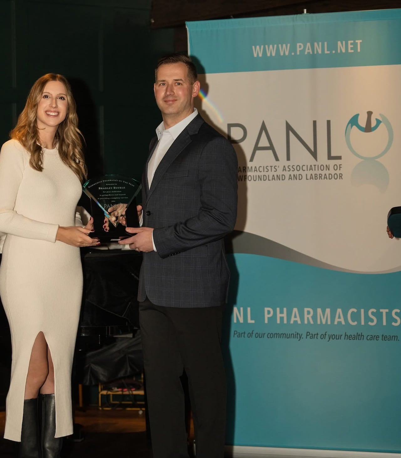 Two people on stage with an award.