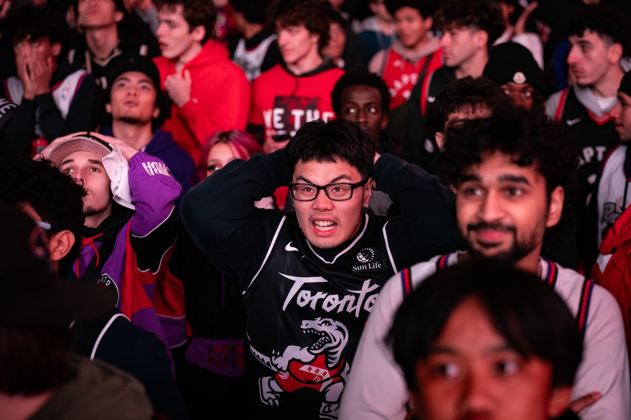 Sports fans react while at an outdoor watch party.