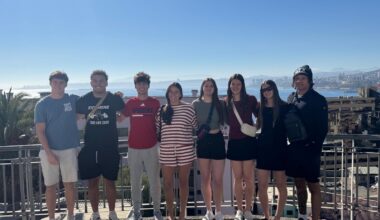 Spider student-athletes pose in front of a cathedral in Chile