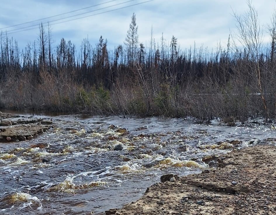 Water runs over a road.