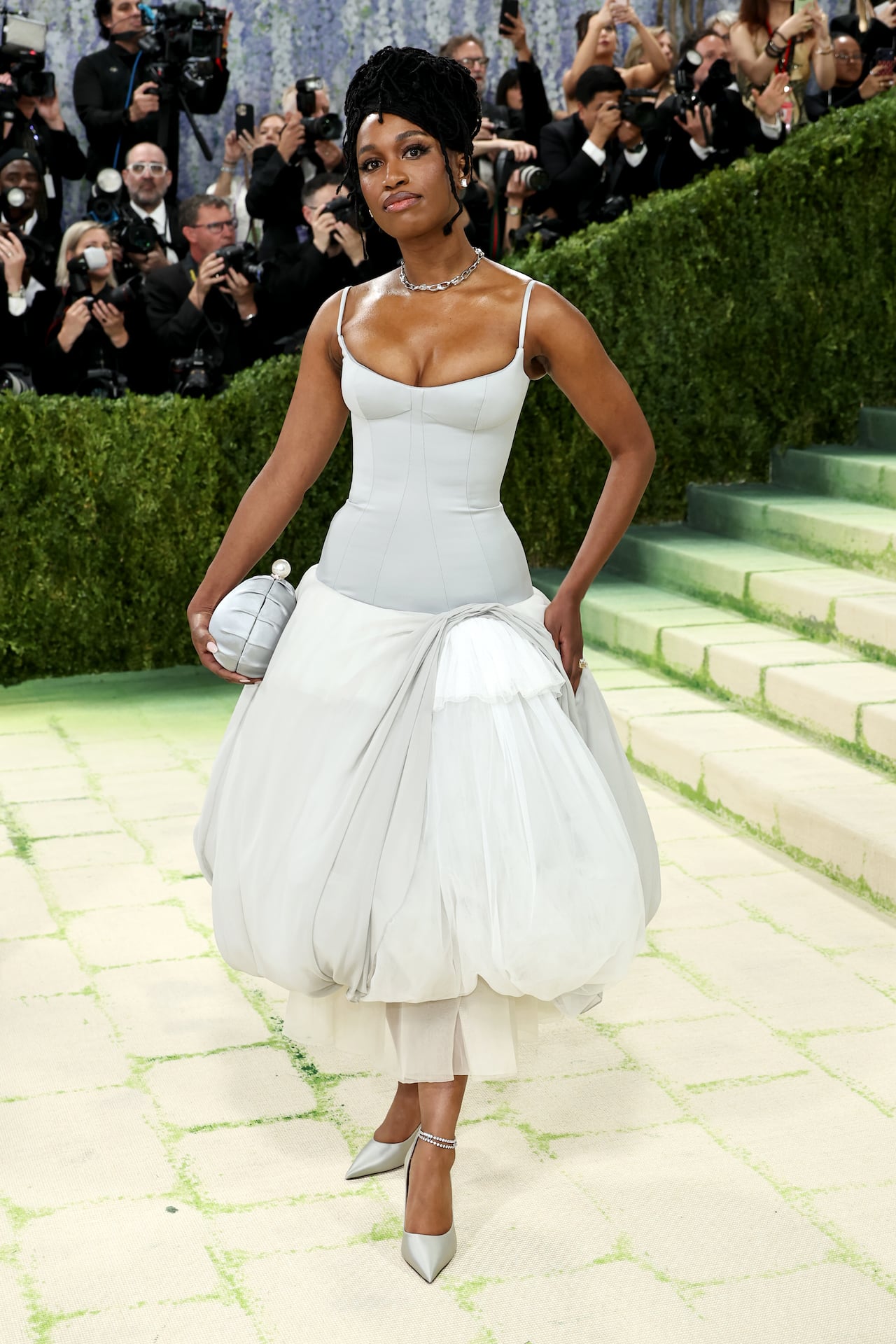 A woman poses for a photo wearing a silver bubble-hem dress.