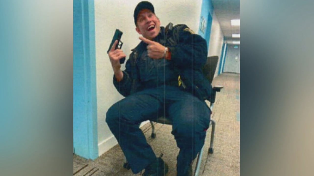 A man hold a gun while smilingq
