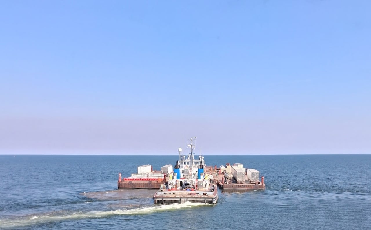 Tug carrying barges on open water