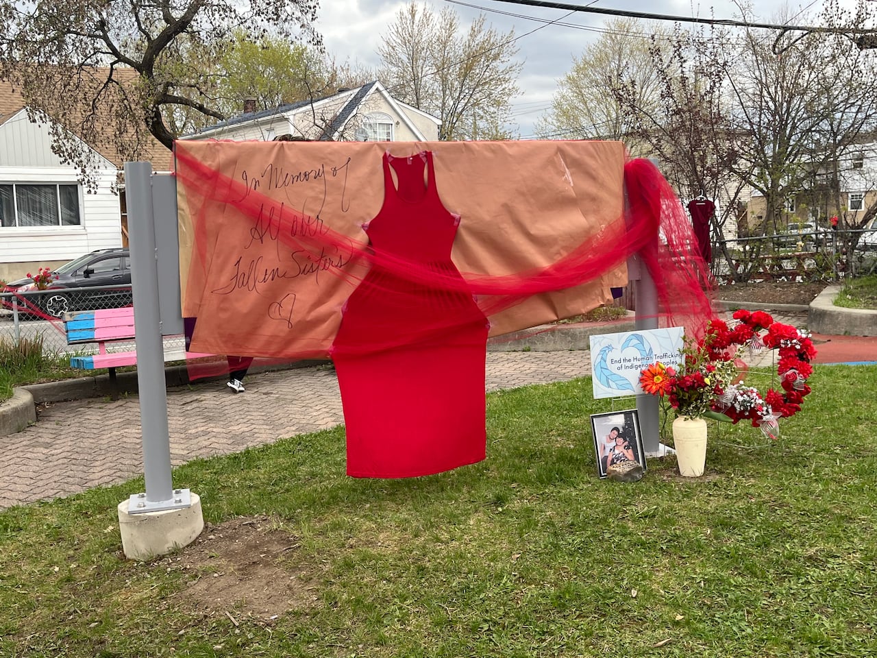 red wrapping paper, ribbon and a red dress cover a large sign