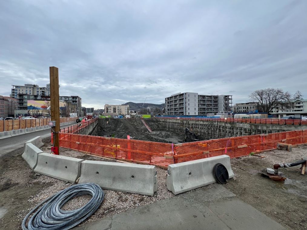 A massive hole in the ground, which is a construction site for a highrise.
