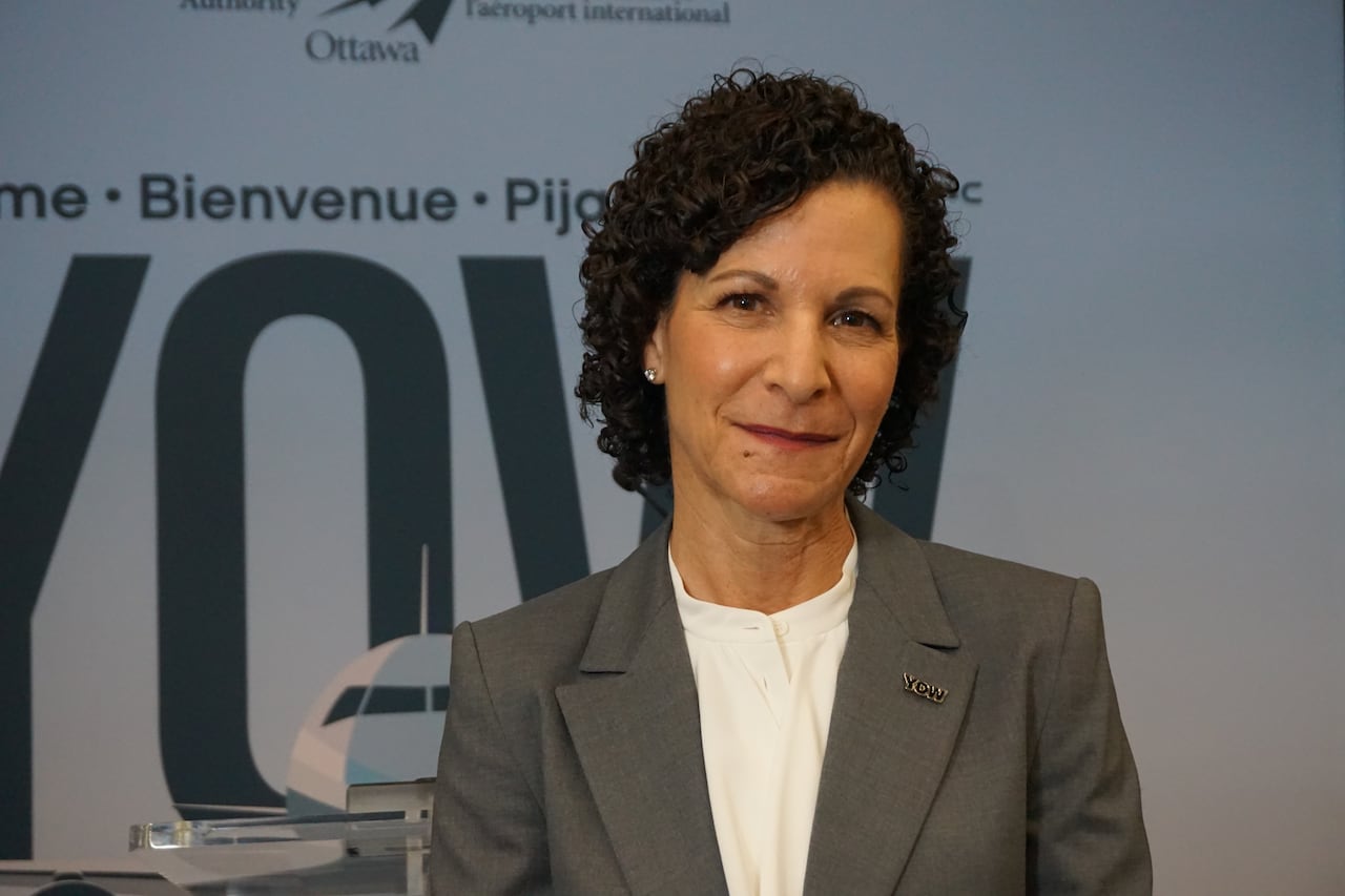 A woman wearing a white shirt and grey blazer