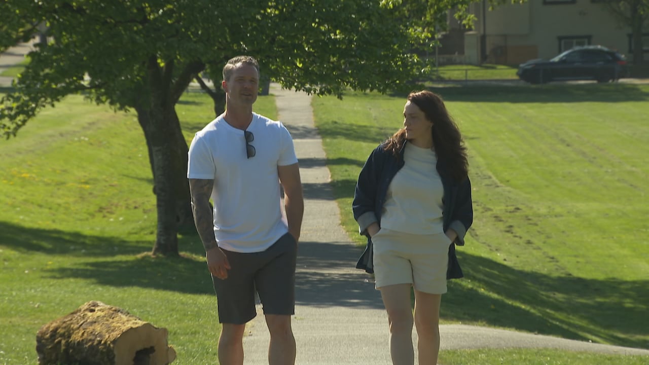 A man and a woman walk in the park.
