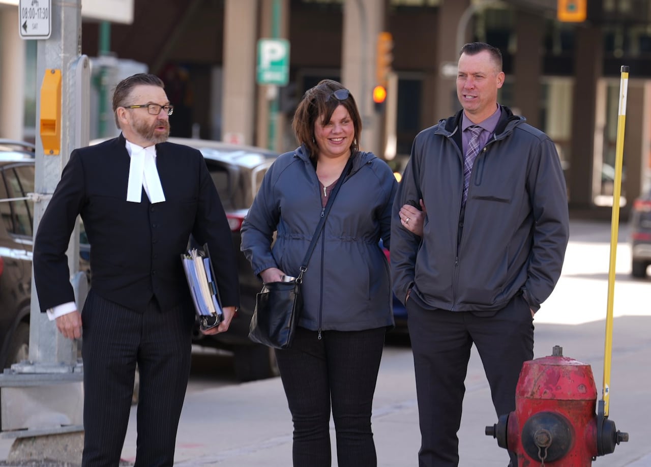 Two men and a woman walk together.