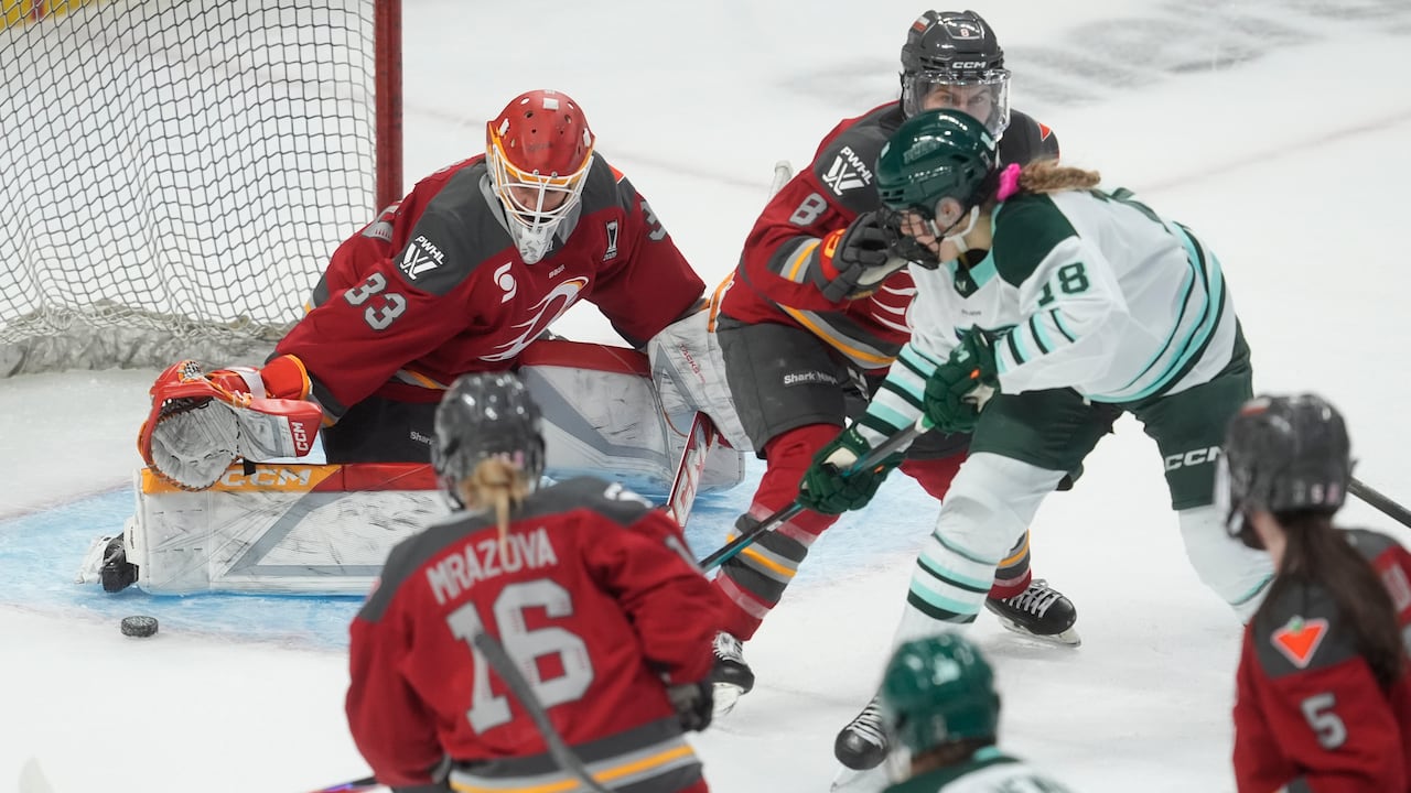 Boston Fleet's Jessie Eldridge, right, puts the puck wide of the net past Ottawa Charge goalie Gwyneth Philips, left, under pressure from Charge's Kathryn Reilly, middle, during first period PWHL playoff action in Ottawa on Friday.