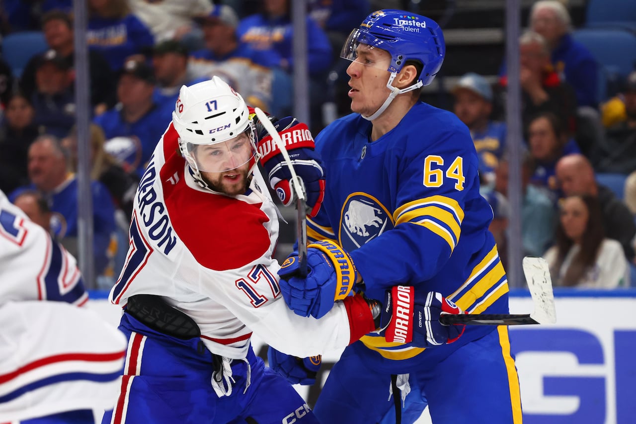 Two opposing hockey players jostle for position in a game.