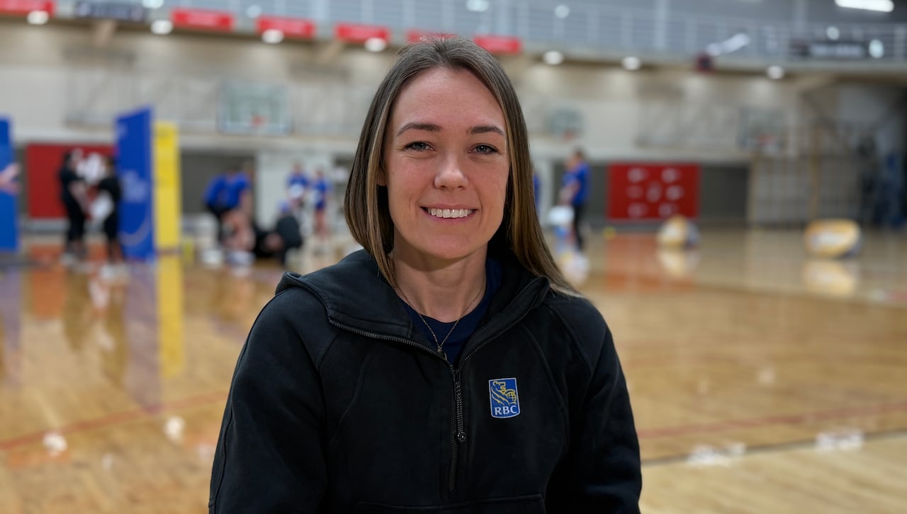 A woman wearing a hoodie in an indoor court.