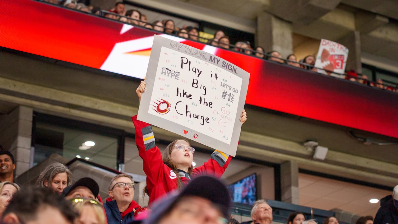 A young fan holds up a sign during a hockey game.