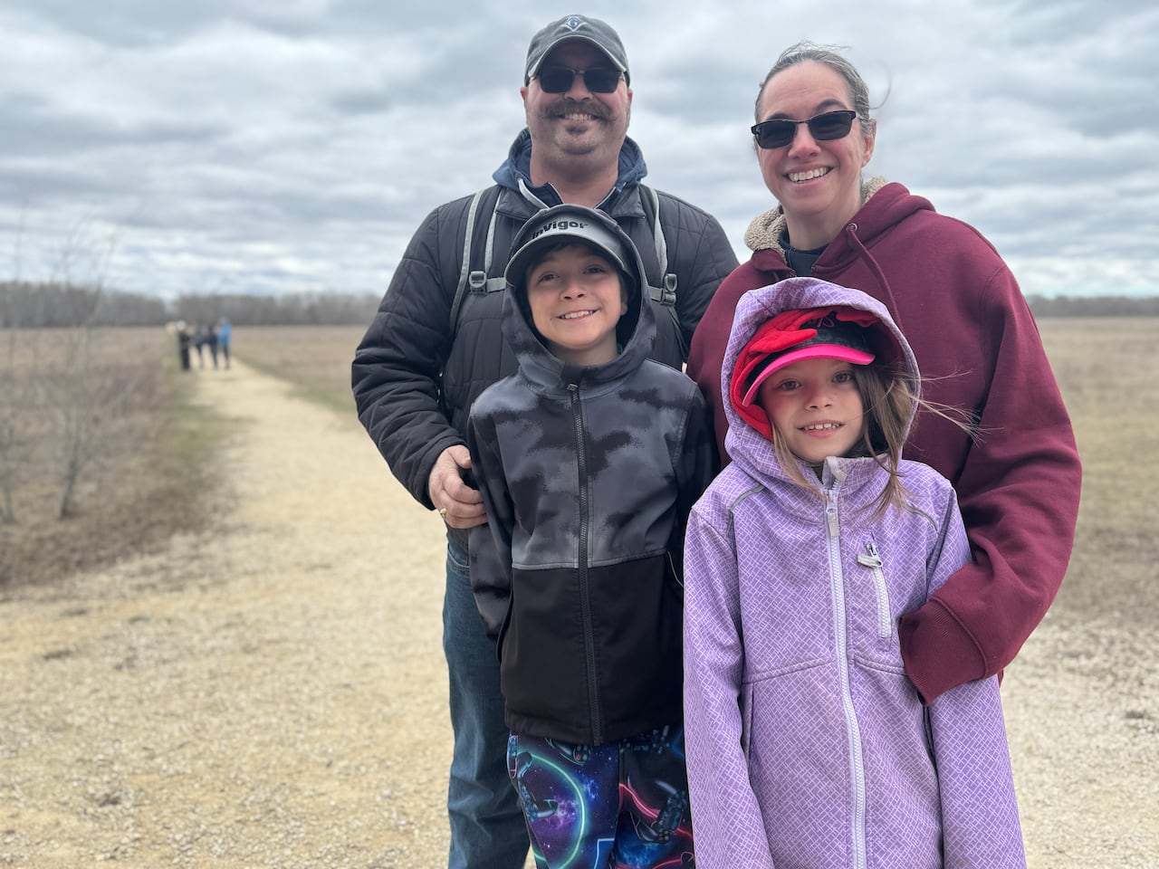 A woman, a man, and two children on an outdoor trail.