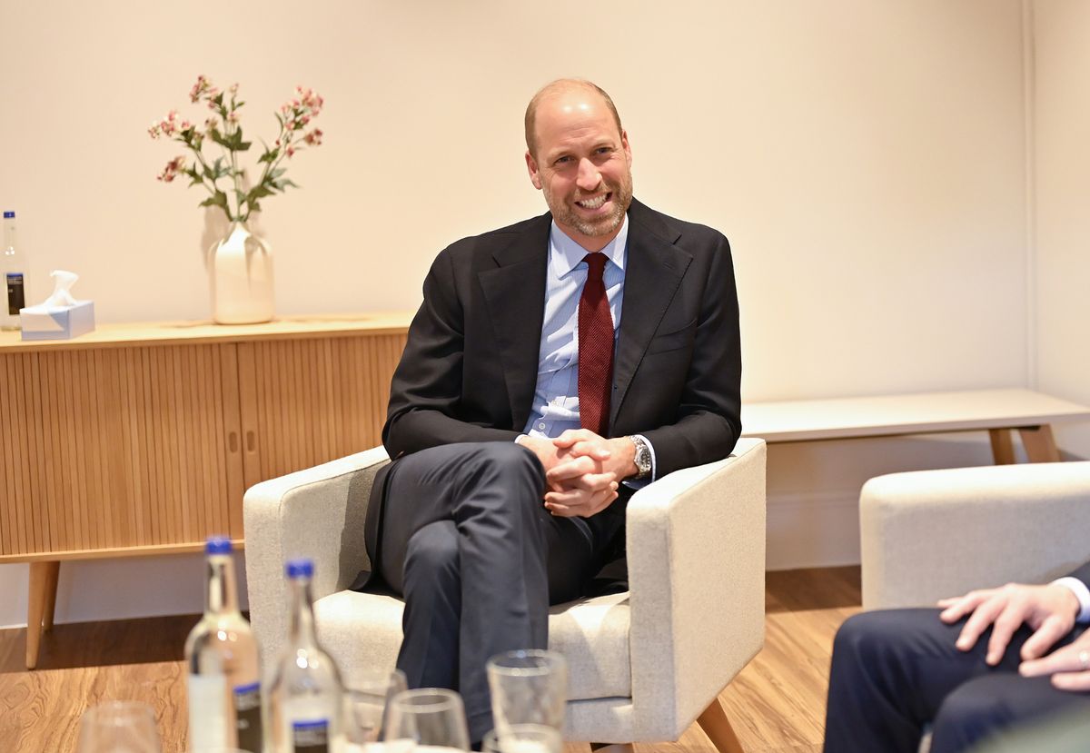 Prince William sitting in a chair, smiling, at the opening of a new mental health facility in Birmingham