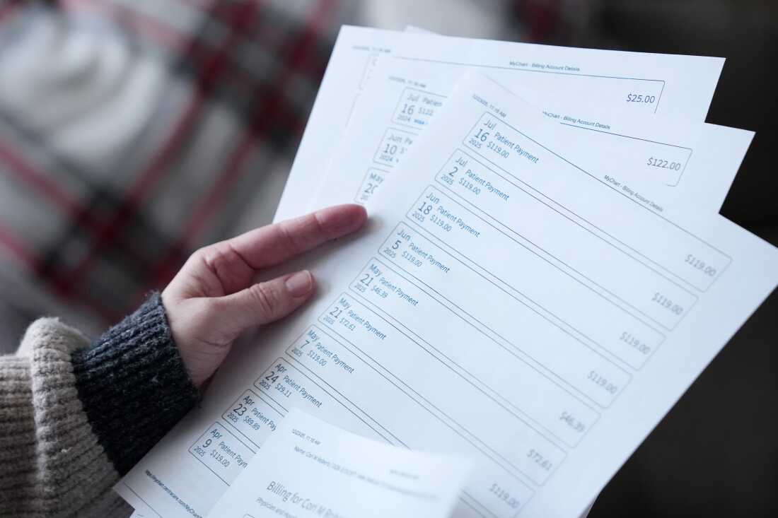 Cori Roberts, who was sued by her healthcare provider after she was unable to make full payments for her treatment, thumbs through copies of her payment records at her home in St. Cloud, Minnesota.