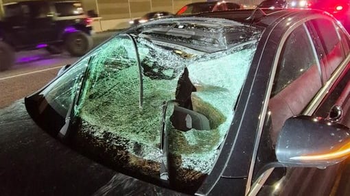 Smashed-in windshield of a dark-coloured vehicle along Hwy. 417