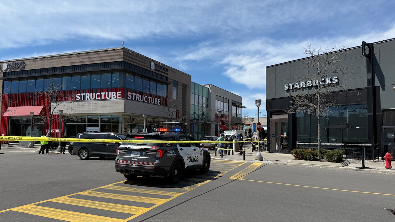 Police vehicles and tape in Don Mills parking lot