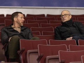 Johnson and Allvin sit side by side in the stands.
