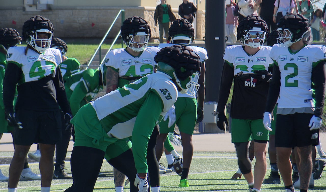 Football players in green and white practise the game.