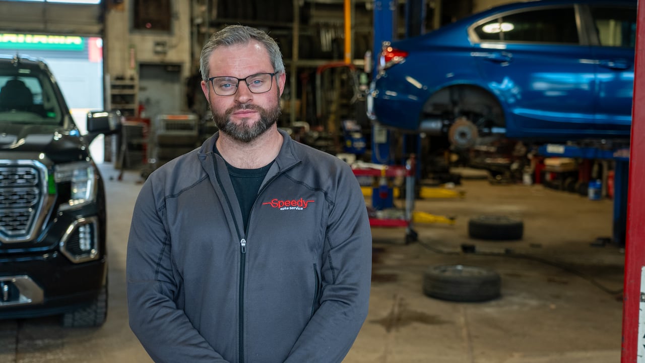 Man stands in an auto garage
