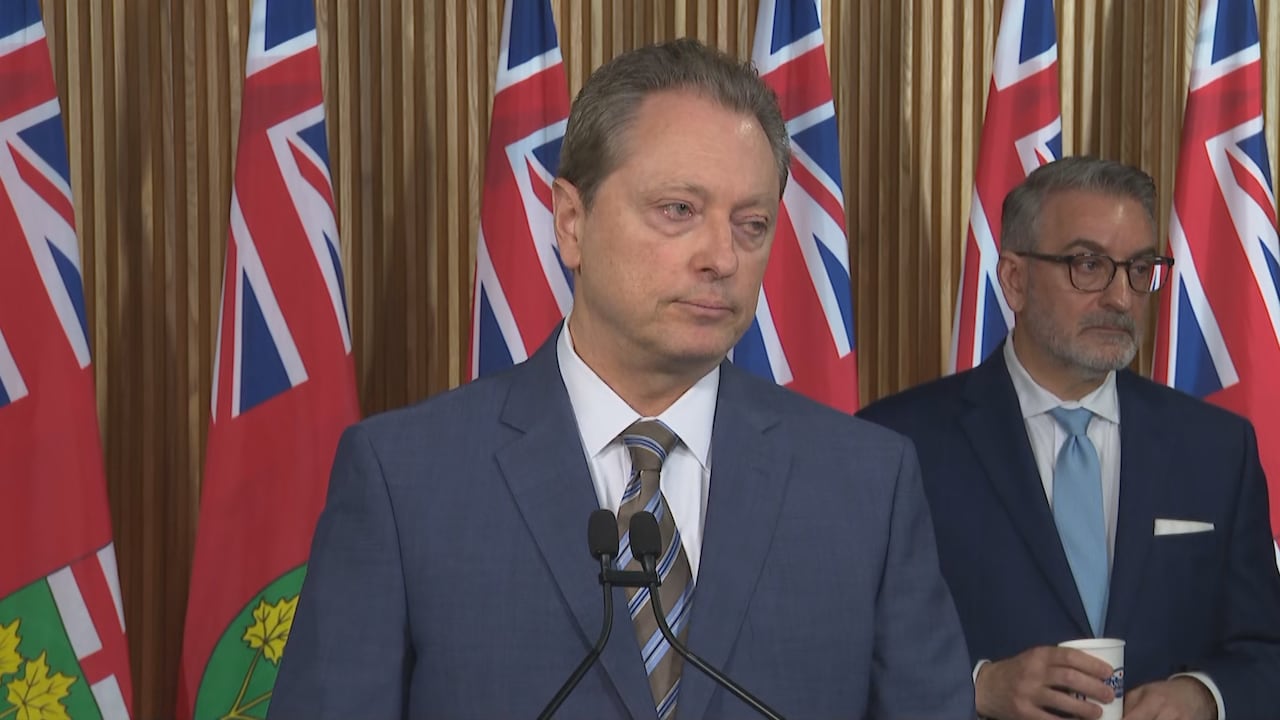 A man in a suit looks at a person asking a question.