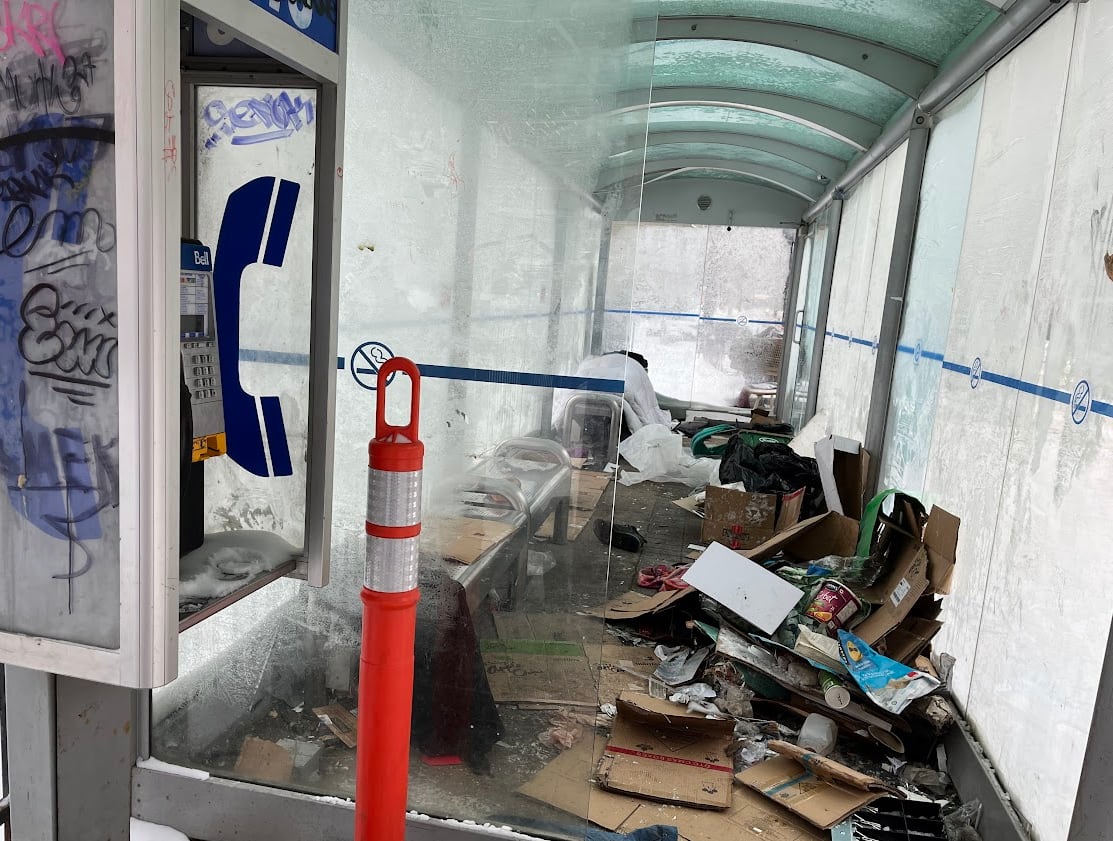 A bus shelter is seen filled with trash and graffiti