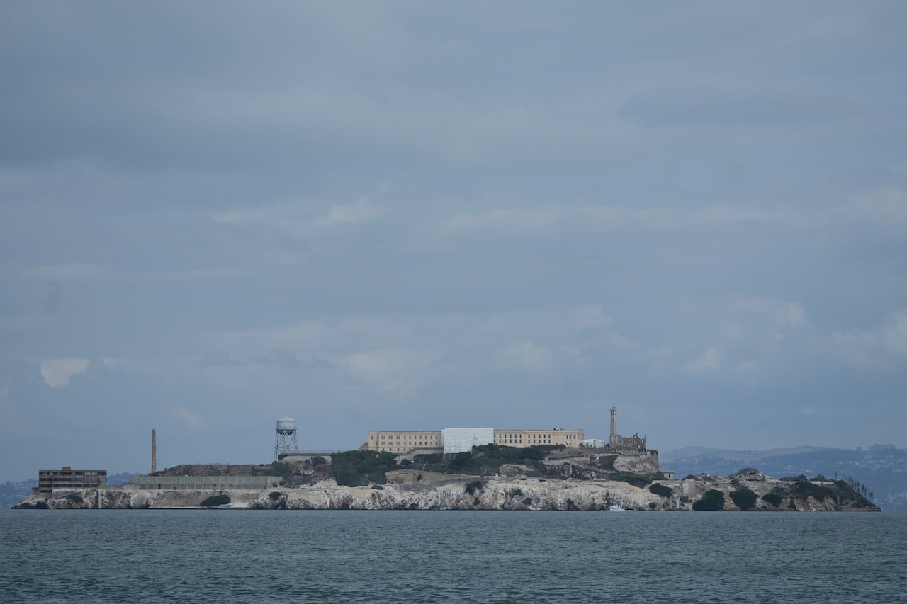 A cluster of buildings is seen on an island in a large body of water.