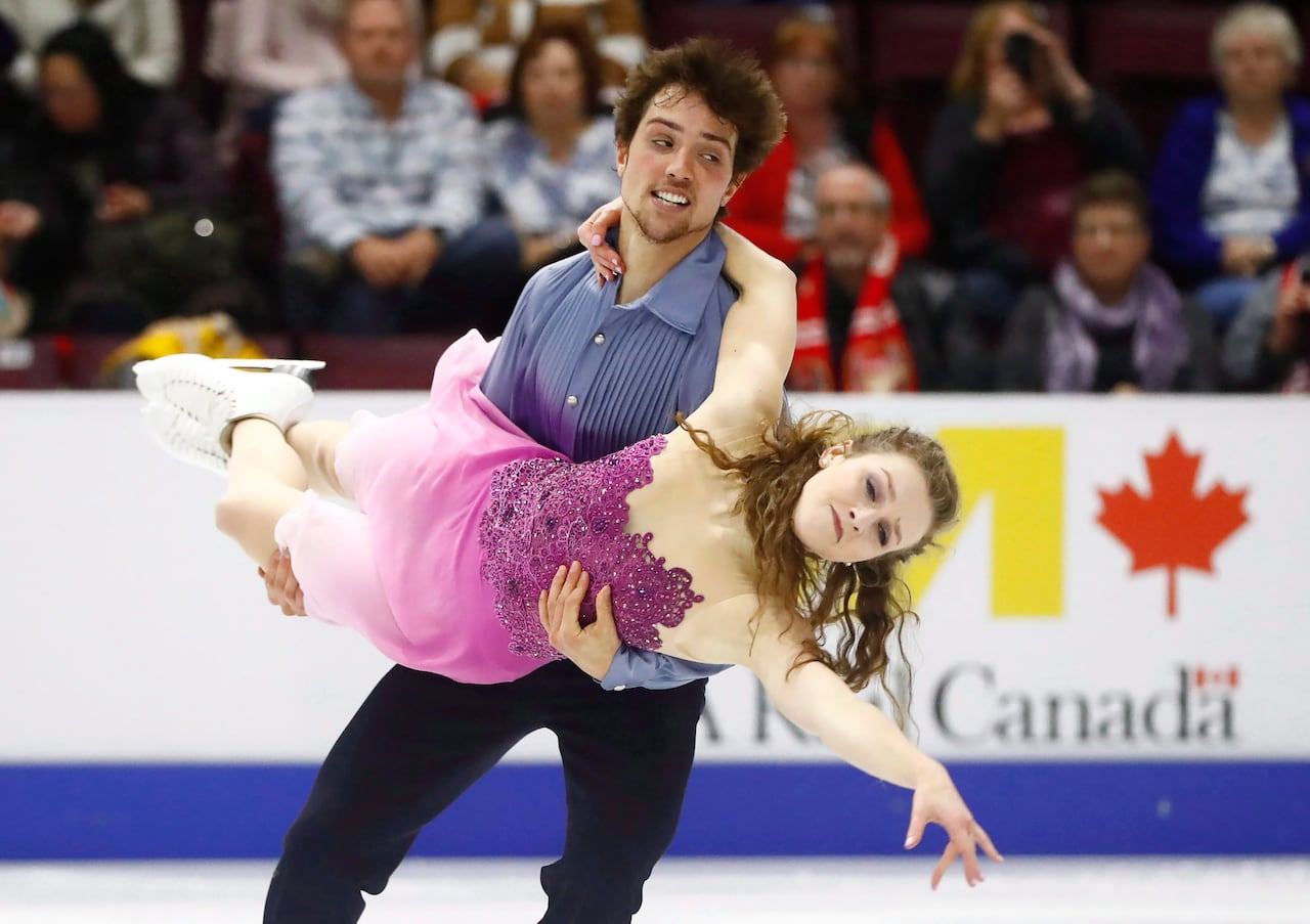A figure skating performance shows a couple doing a trick on ice.