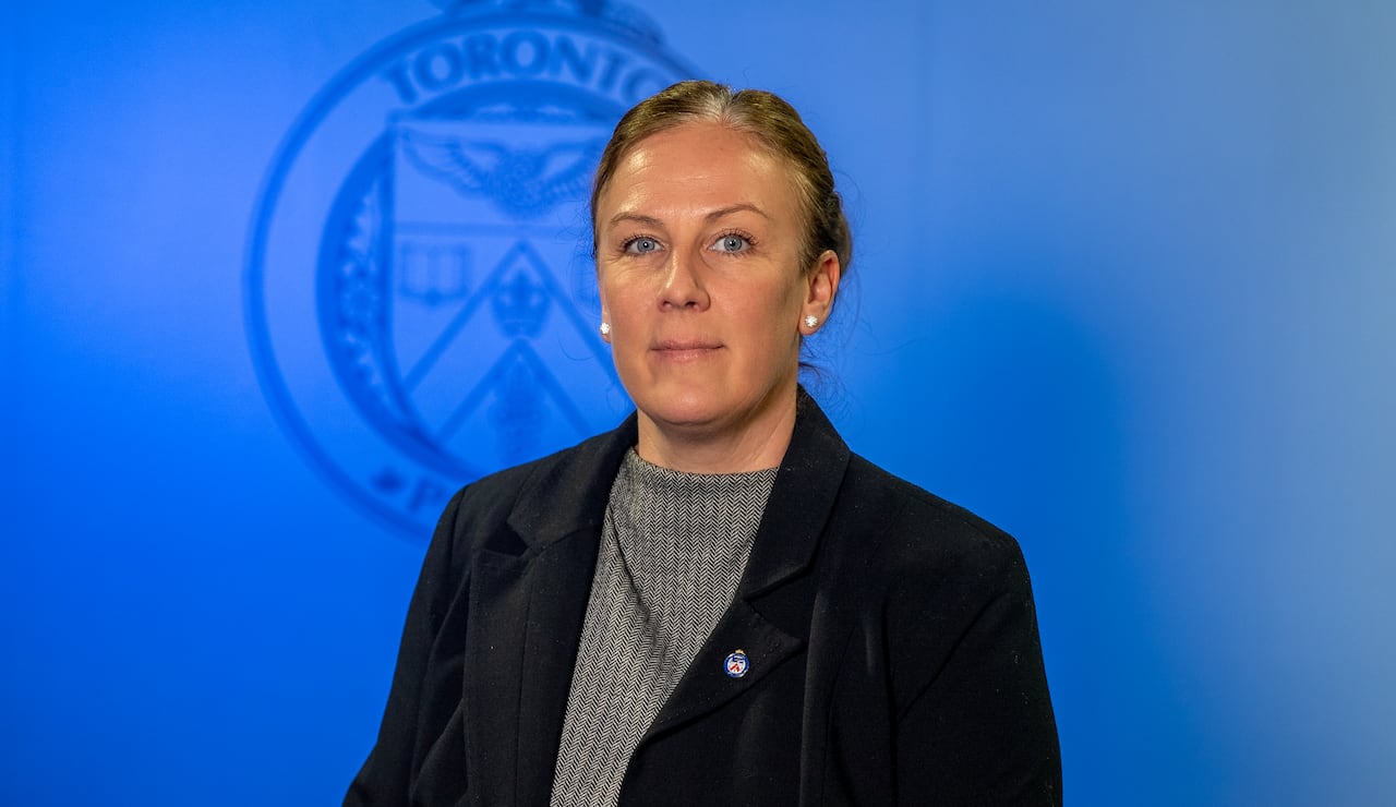 Woman standing in front of the Toronto Police Service logo.