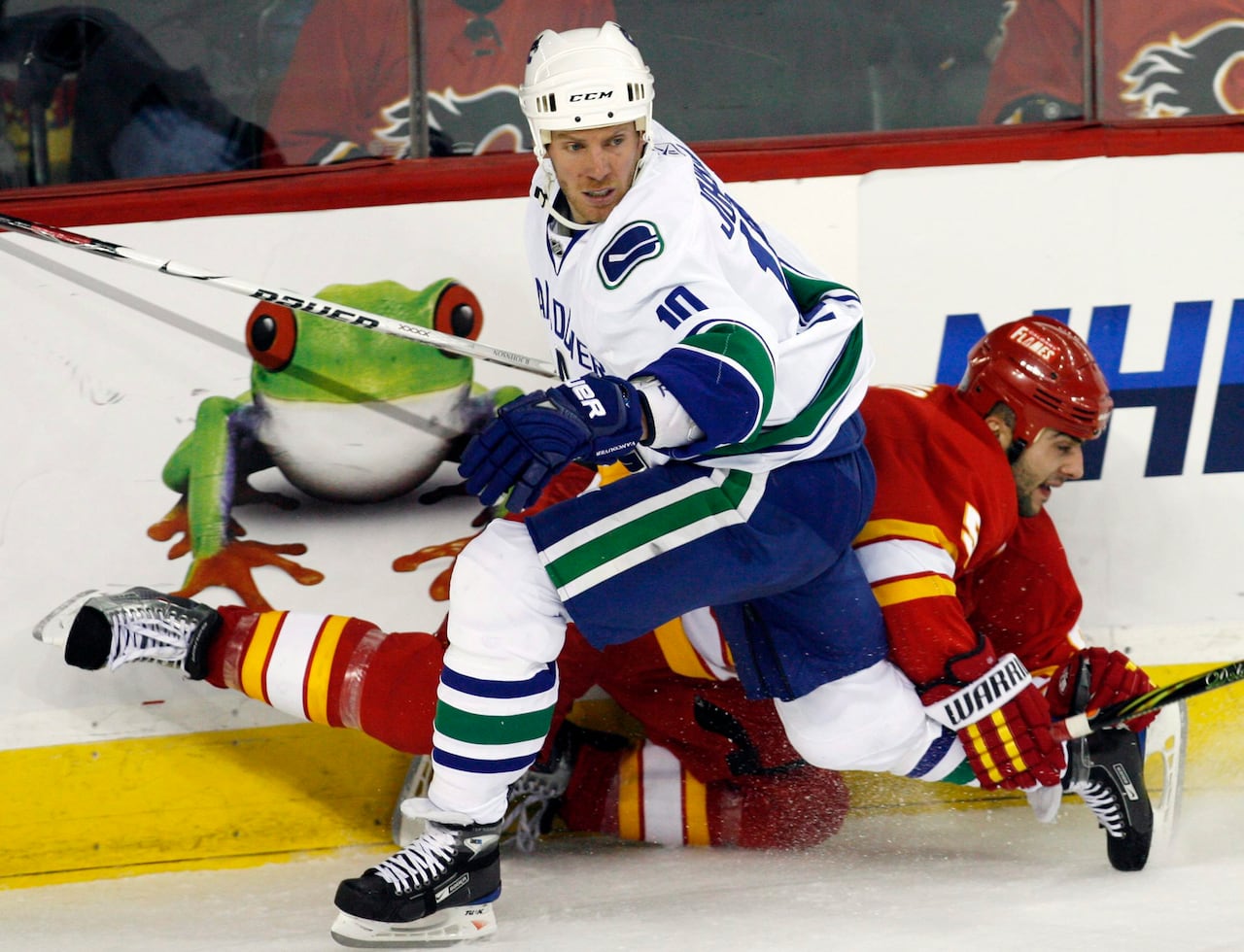 Hockey players collide against the boards.