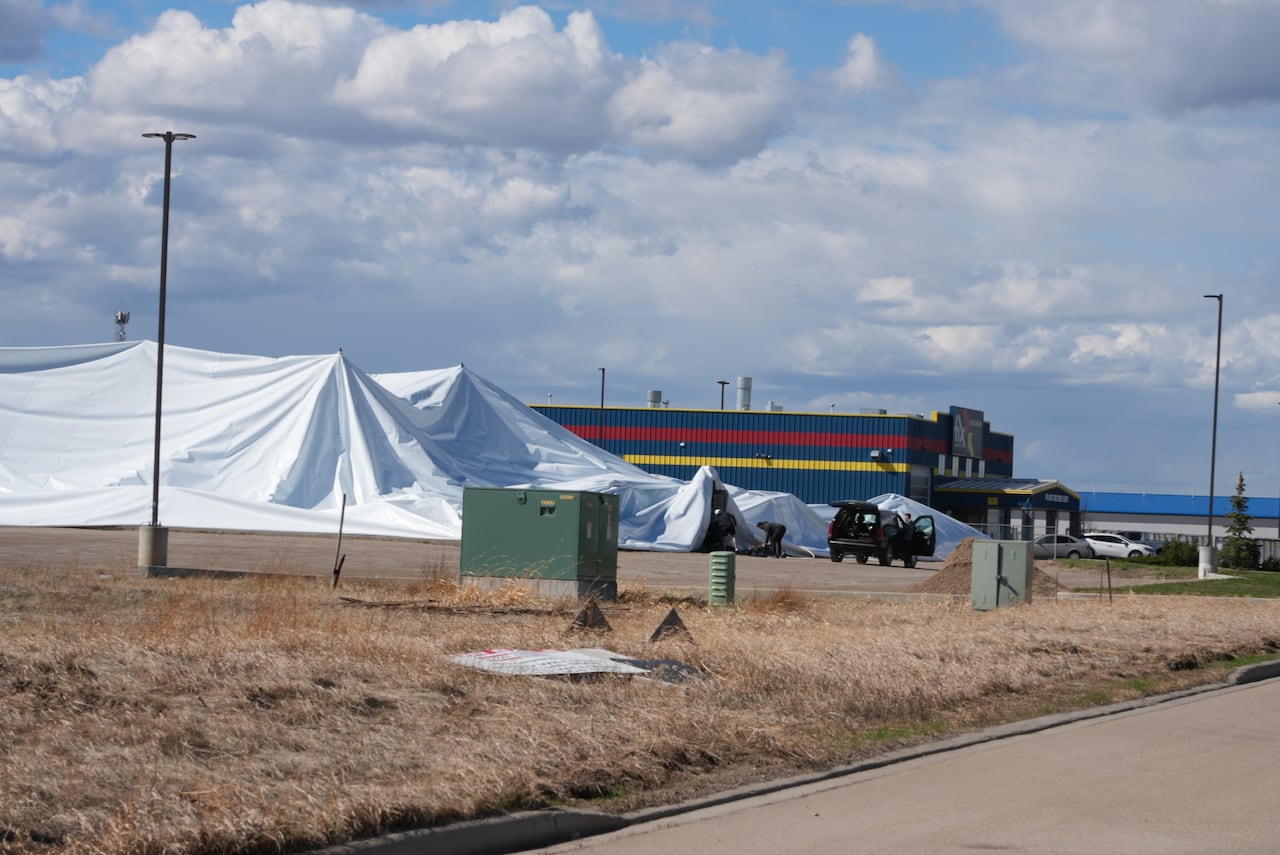 A white tarp lays deflated on top of a structure.
