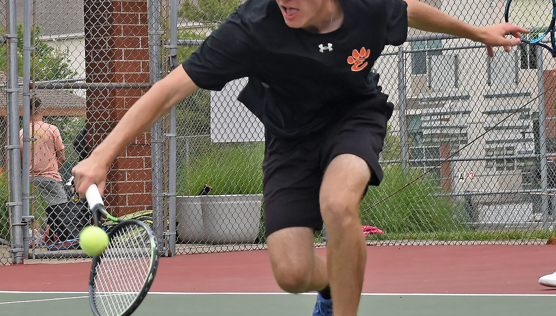 Edwardsville’s John Almos reaches for a backhand during the third-place doubles match of the Class 2A Edwardsville Sectional on May 24 inside the EHS Tennis Complex. 