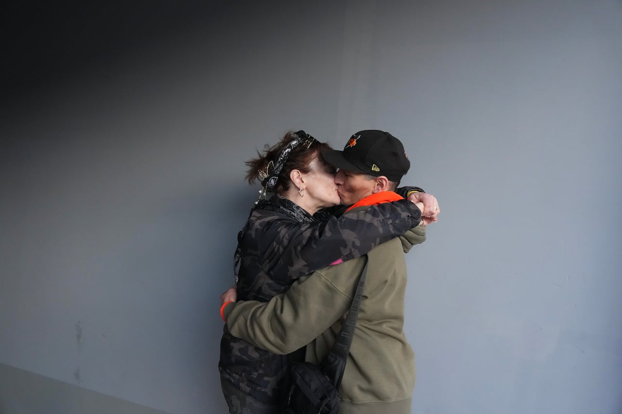 Two people embrace and kiss.