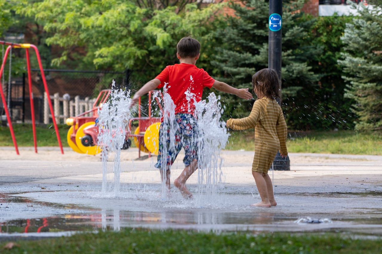 Two kids play in a splash pad.