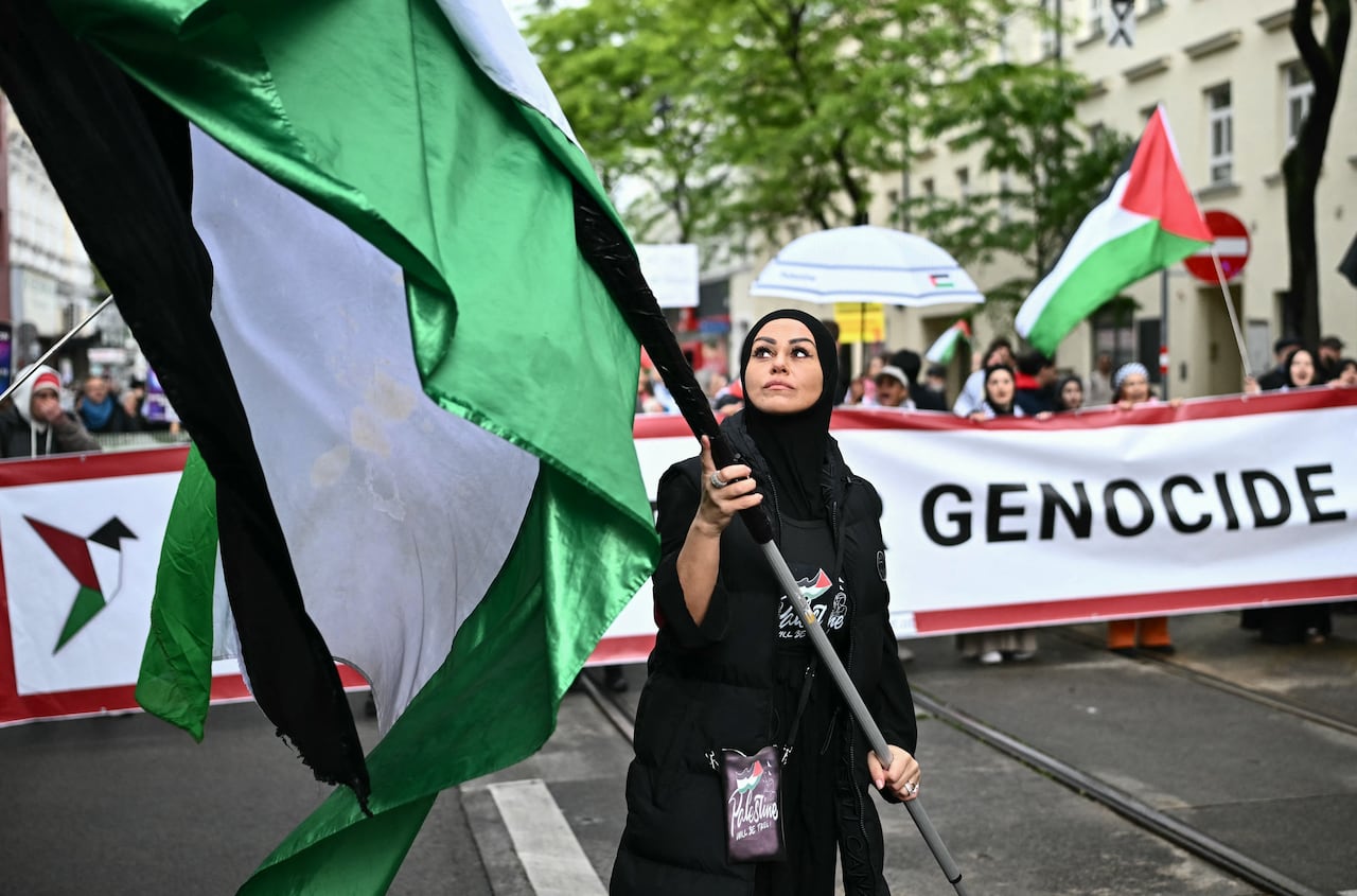 Protesters hold up flags and banners during a march.