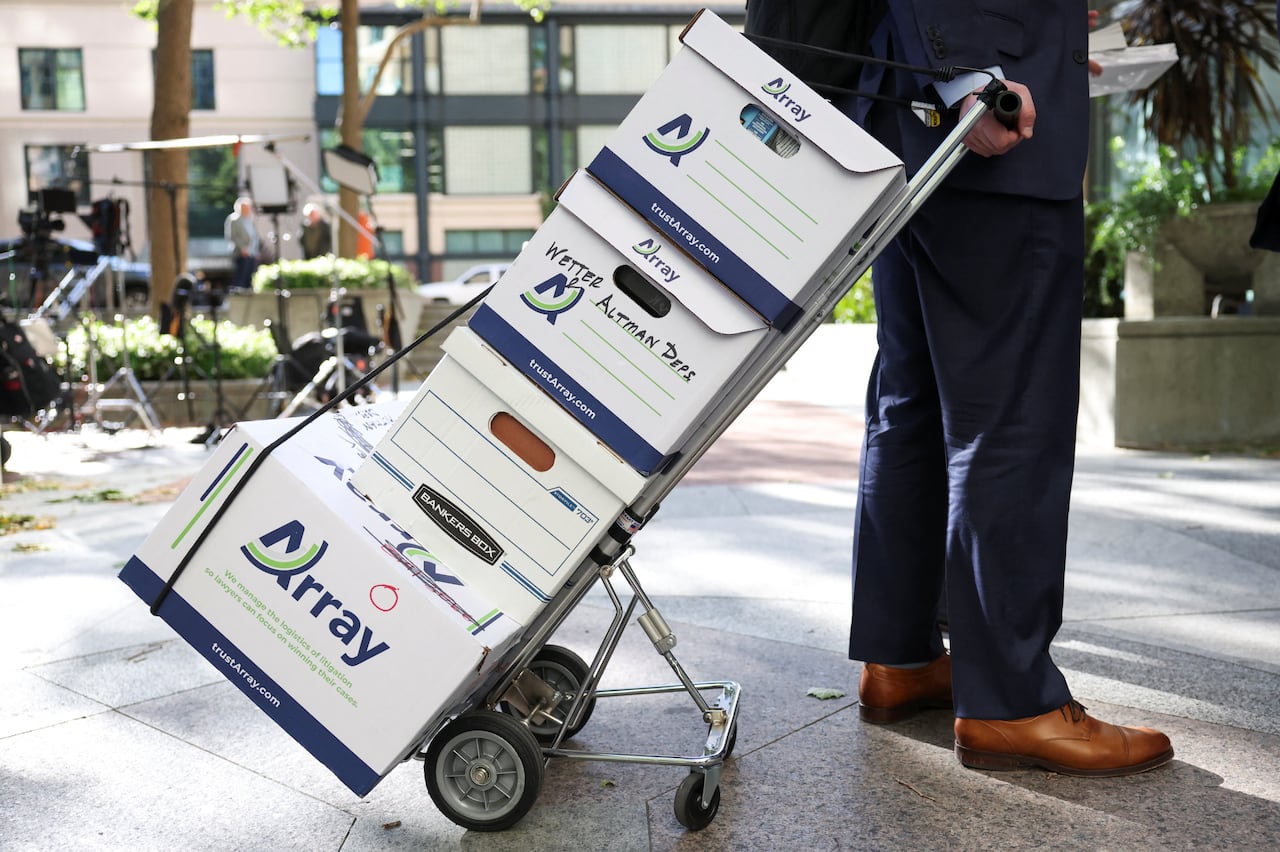 A person wheels boxes on a dolley.