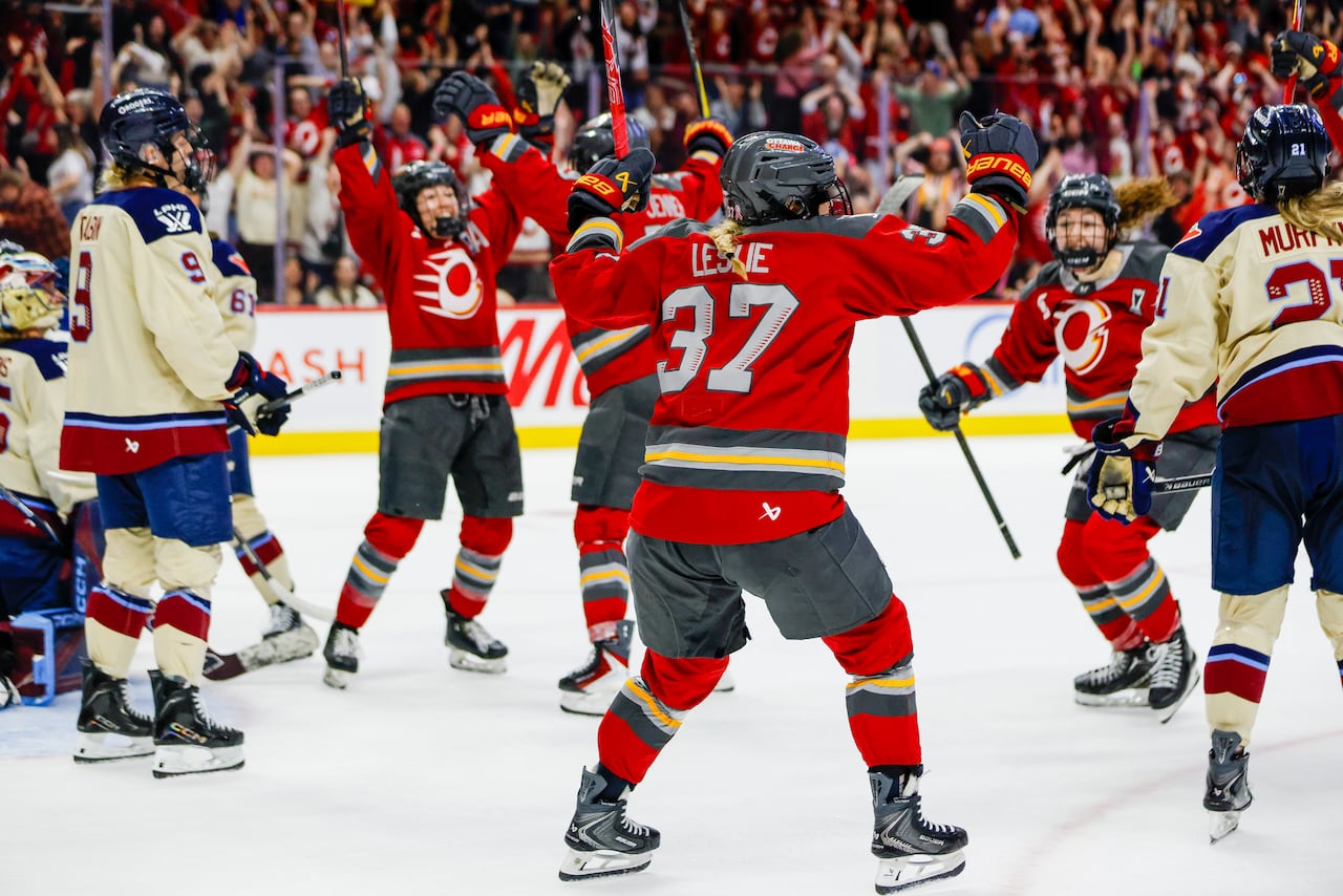 Hockey players celebrate a goal on the ice.