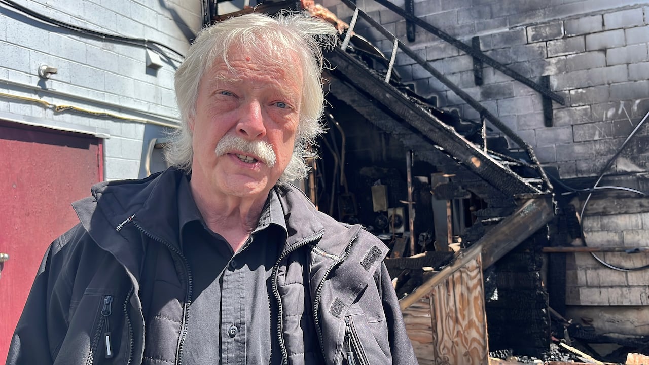 A man outside a charred building.