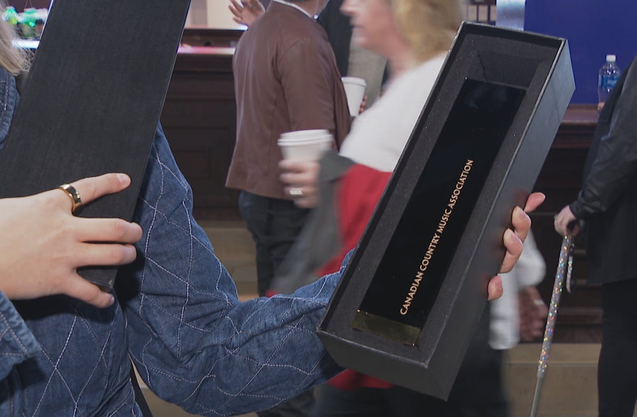 Person holding box with CCMA award inside.