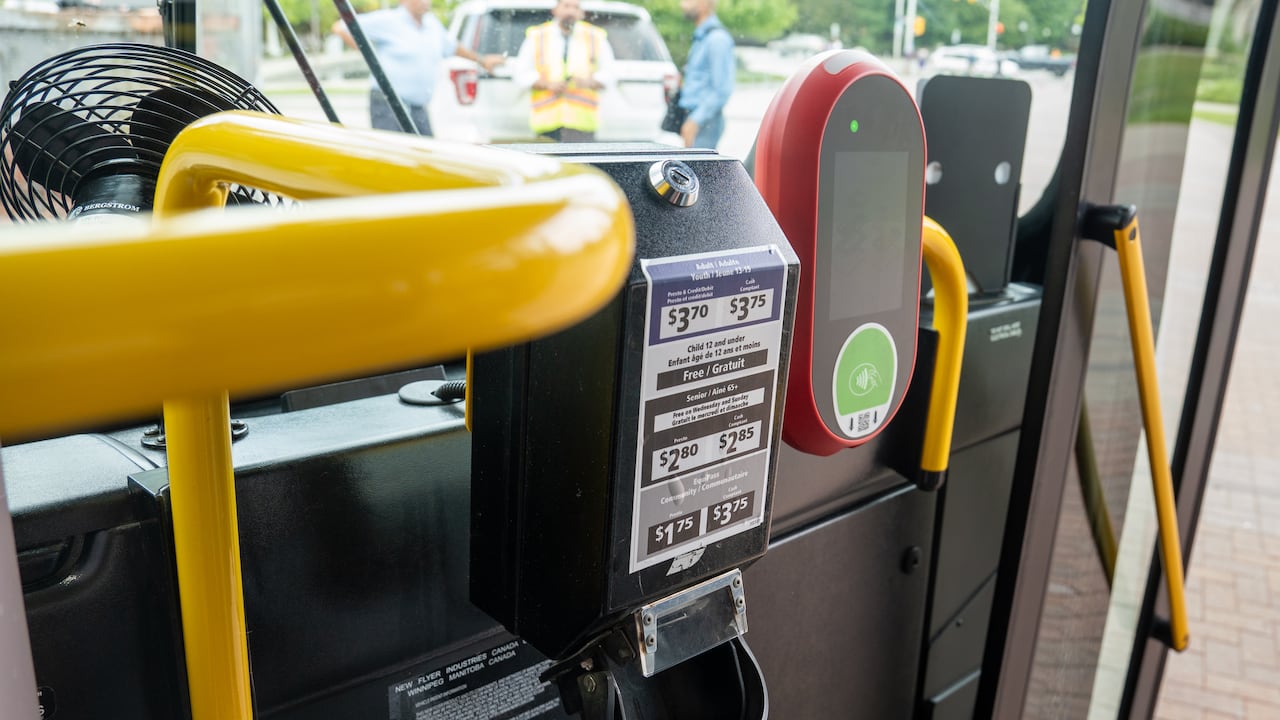 A red pay station on a bus.