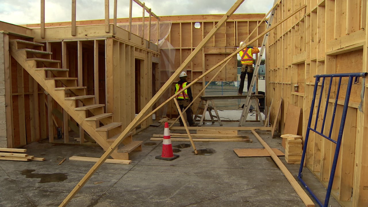 The photo shows two construction worker at a site doing renovation.