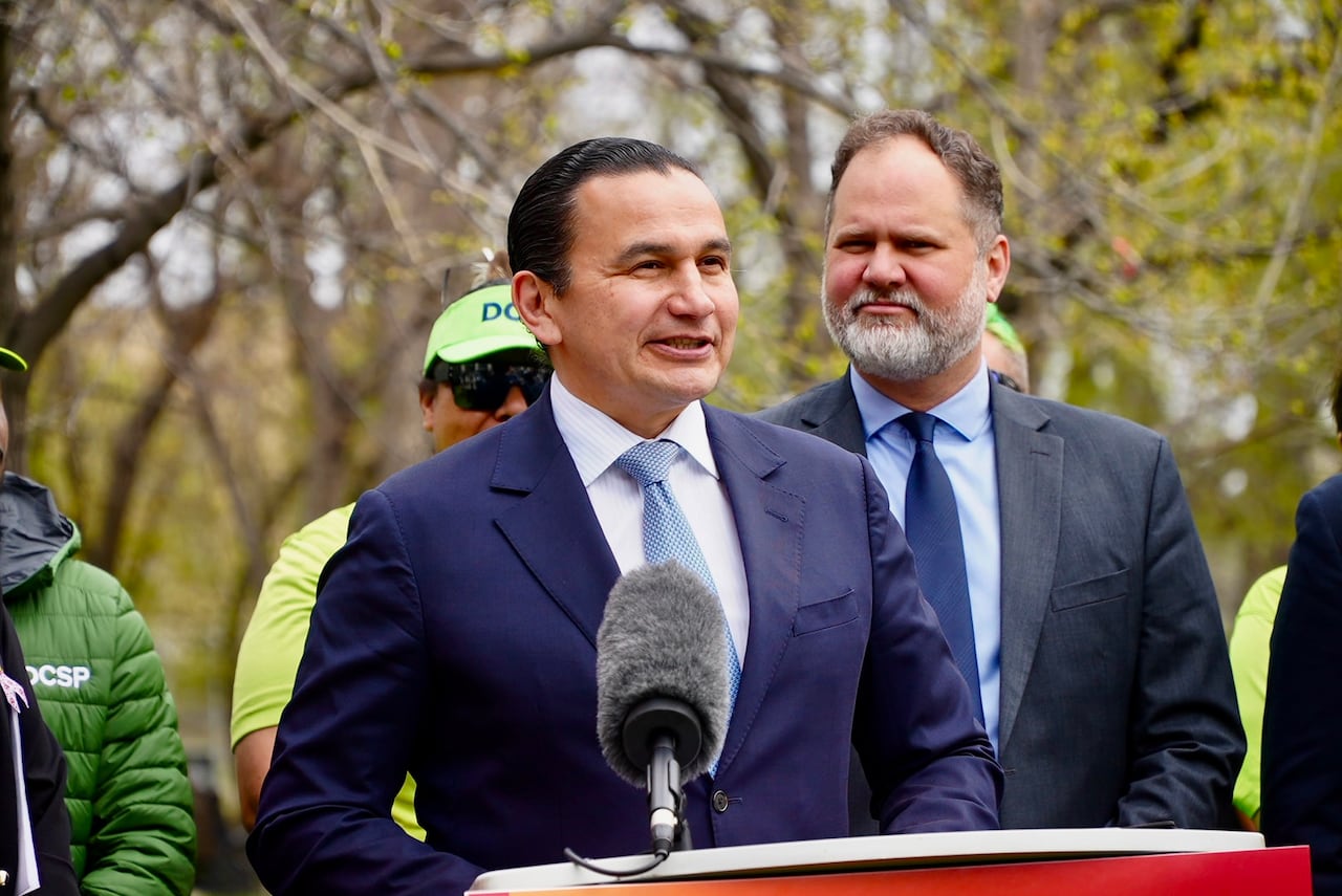 A man in a suit speaks in a podium.