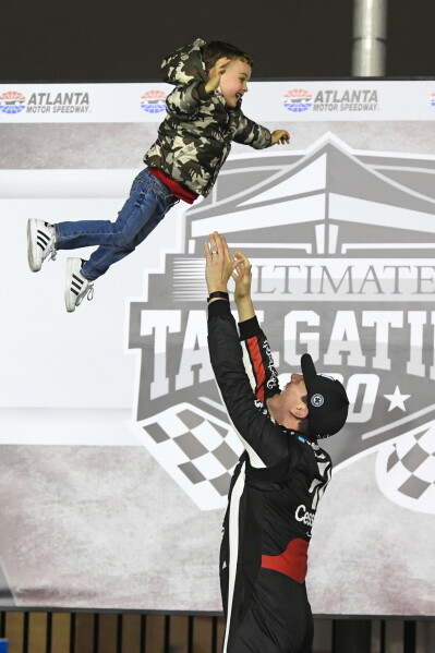 Kyle Busch tosses his son Brexton up in the air while celebrating in Victory Lane after winning the NASCAR Truck Series auto race at Atlanta Motor Speedway on Feb. 23, 2019, in Hampton, Ga. (AP Photo/John Amis, File)