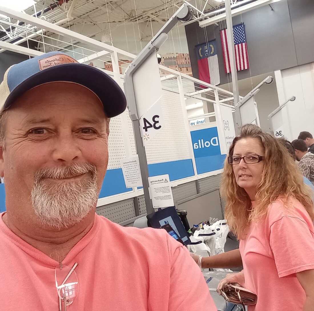 Stanley Sears is smiling broadly in a selfie. His sister Debra Pierce is at a self-checkout machine at a Walmart. They are both wearing pink shirts.