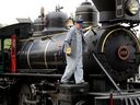 Locomotive engineer John Reynolds prepares for his first passengers of the day aboard the locomotive 107 steam engine in Fort Edmonton Park, Thursday June 1, 2023.