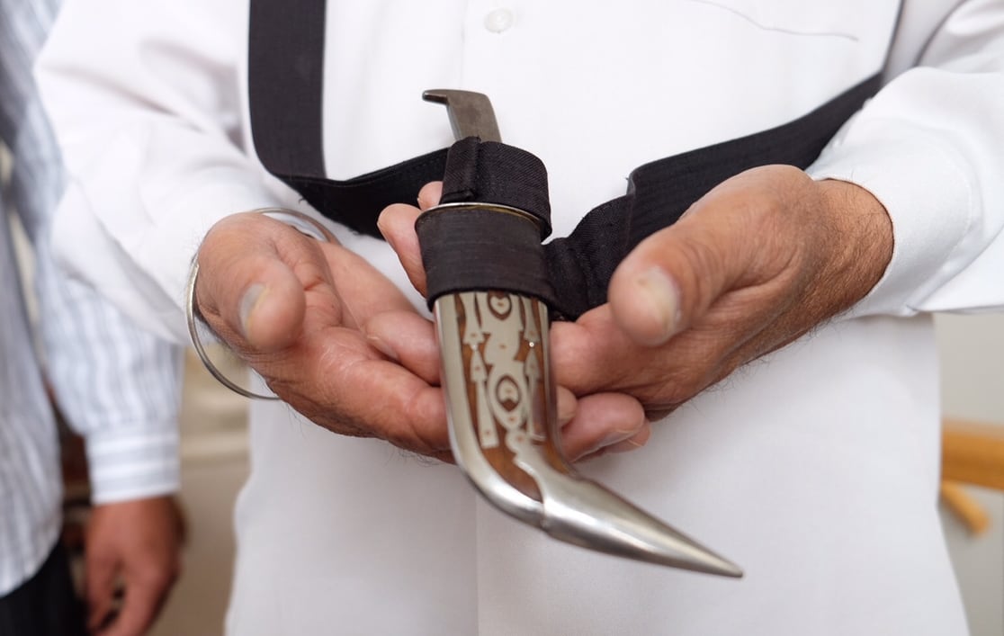 Hands hold a small, silver dagger