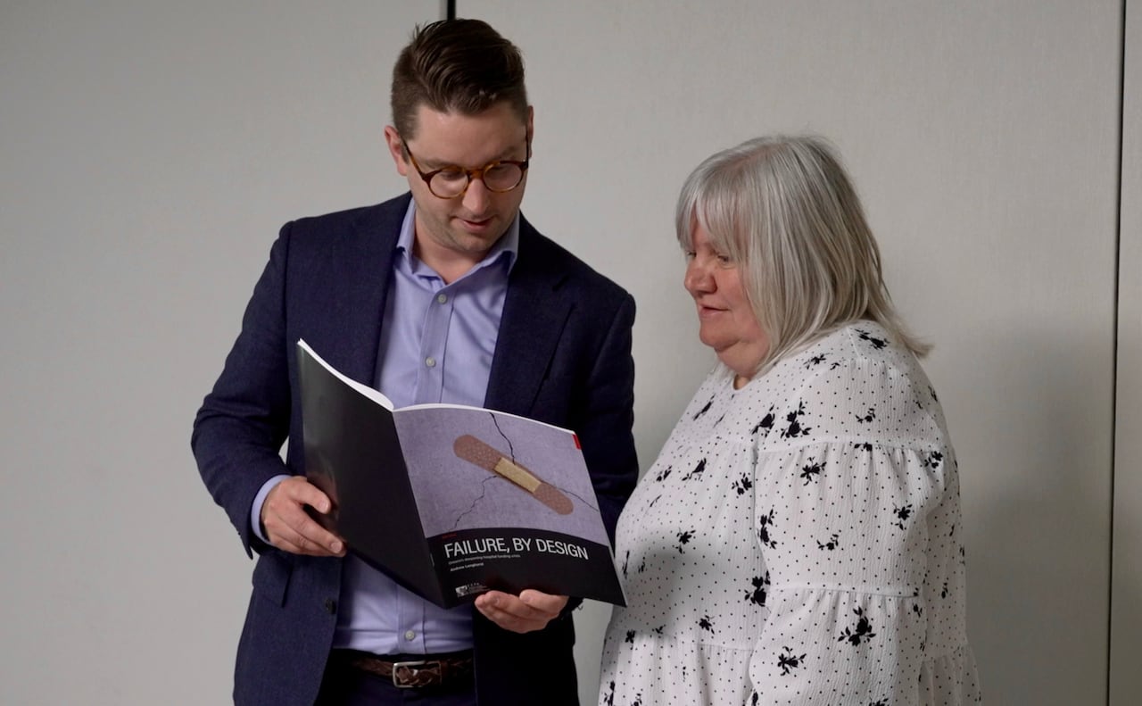 Man and woman stand next to each other and chat over report entitled, "Failure, by Design"