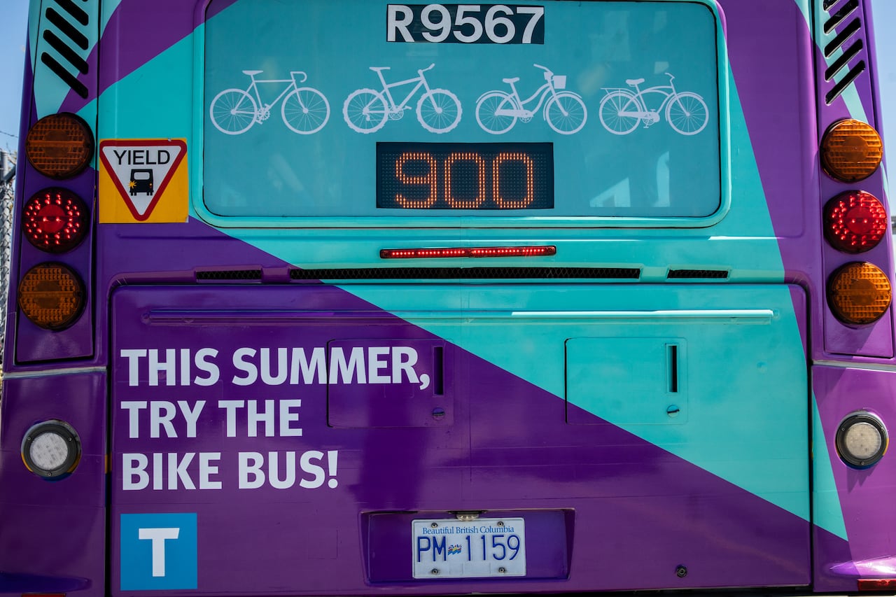 A 900 bus route bus with advertising reading 'This summer, try the bike bus!'